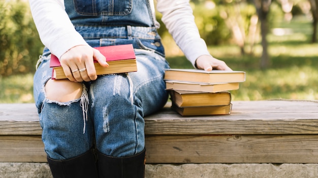 Persoon zittend op een tafel met boeken in het park