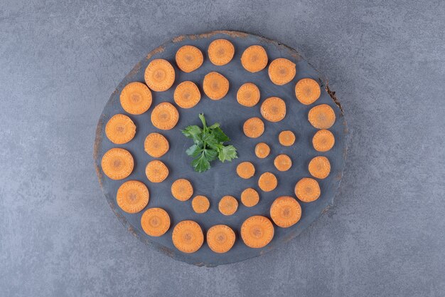 Gratis foto peterselie en gesneden wortelen bord, op het marmeren oppervlak.
