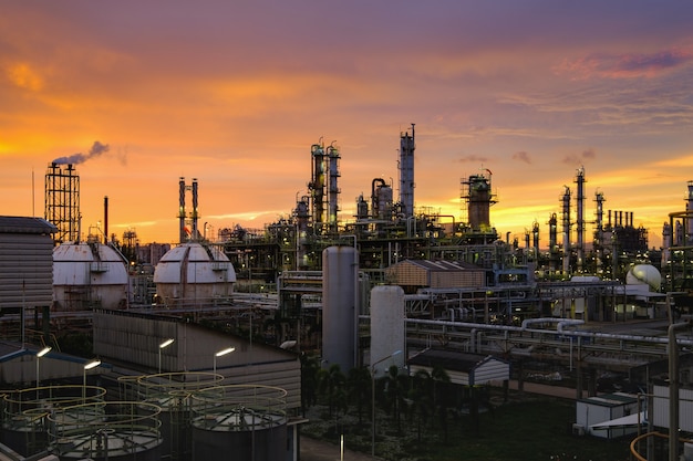 Petrochemische industriefabriek bij zonsondergang, productie van industriële olieraffinaderij