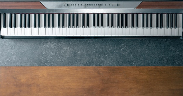 Gratis foto piano toetsenbord op een donker marmer en hout oppervlak top view