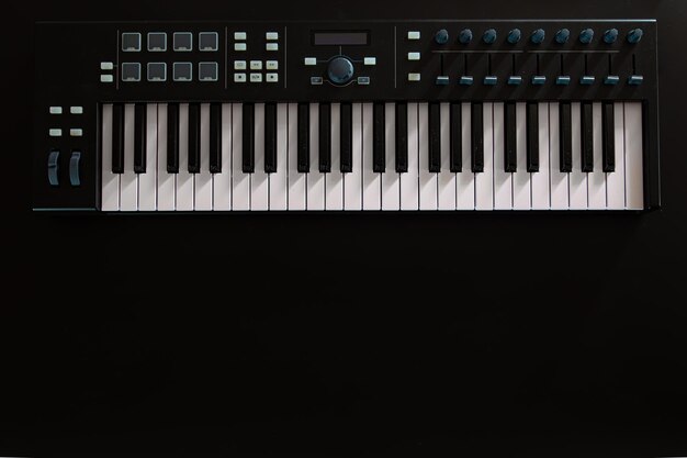 Pianotoetsen synthesizer op een zwarte achtergrond plat lag
