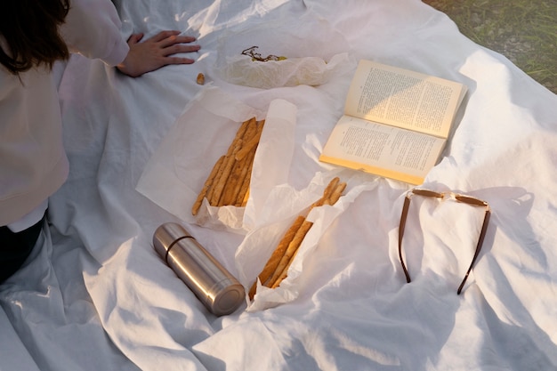 Picknick onder hoge hoek met boek en snacks