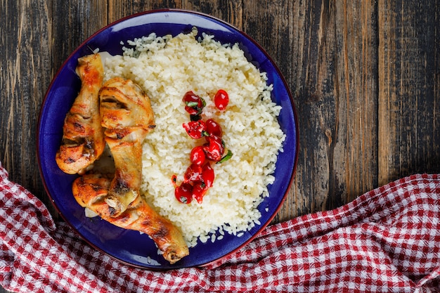 Gratis foto pilaf in een plaat met kippenvlees, veenbessen op houten en keuken handdoek