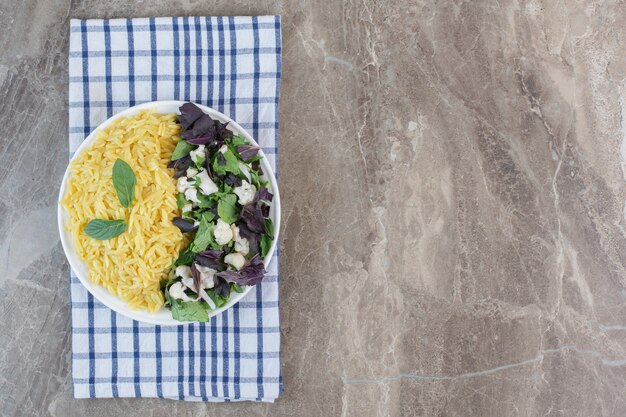 Pilau met smakelijke salade op een plaat op marmer.