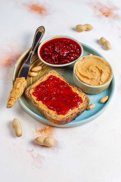 Pindakaasbroodjes of toast met frambozenjam.