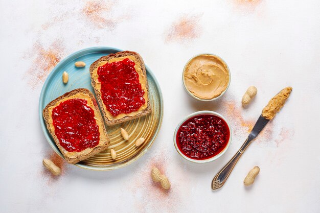 Pindakaasbroodjes of toast met frambozenjam.
