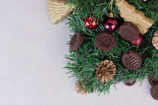 Pinecones met kerstballen en koekje op witte ondergrond