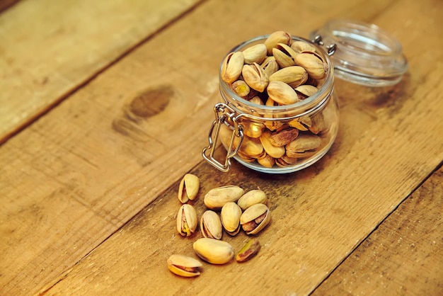 Pistachenoten in kom op oude houten tafel achtergrond