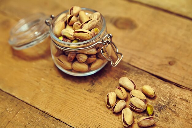 Pistachenoten in kom op oude houten tafel achtergrond