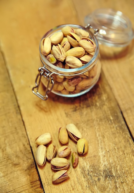 Pistachenoten in kom op oude houten tafel achtergrond