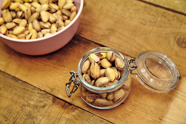 Pistachenoten in kom op oude houten tafel achtergrond