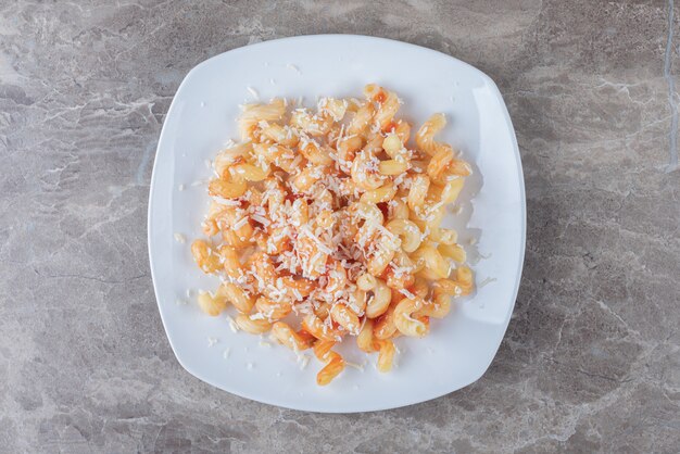 Pittige pasta met tomatensaus, op het marmer.