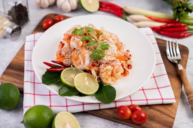 Pittige salade met garnalen op een witte plaat. Thais eten.