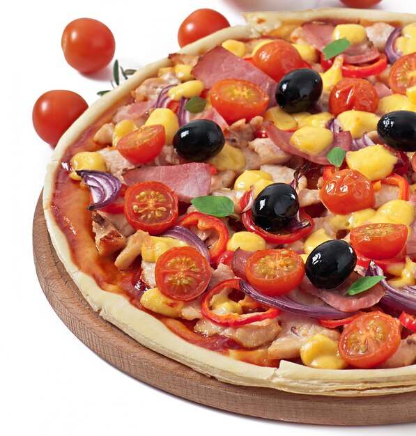 Pizza met groenten, kip, ham en olijven geïsoleerd op wit