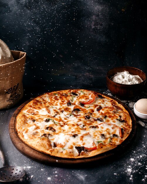 Pizza met kaas op de bruine houten oppervlak op het lichte oppervlak