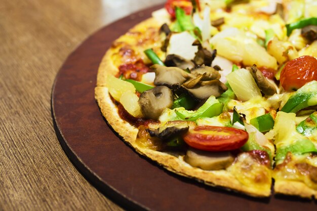 Pizza met kleurrijk plantaardig bovenste laagje klaar om worden gegeten