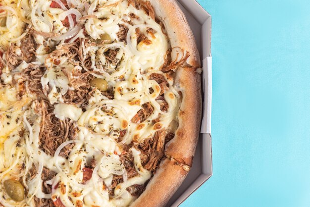 Pizza op de tafel in licht blauwe kleur