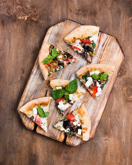 Gratis foto pizzaplakken op scherpe raad boven mening