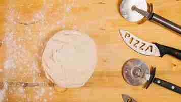 Gratis foto pizzasnijders en messen in de buurt van deeg