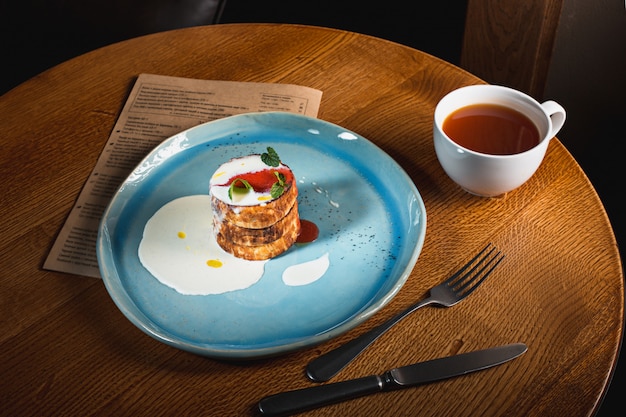 Plaat met smakelijke pannenkoeken op houten tafel