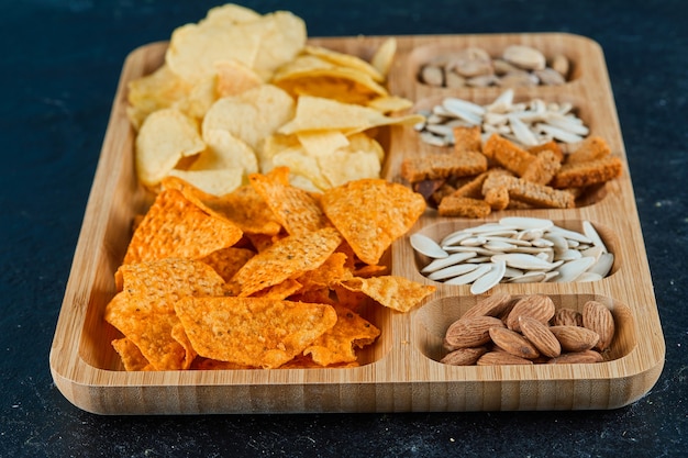 Plaat van diverse snacks op een donkere tafel.