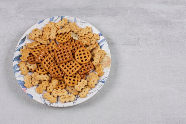 Plaat van verschillende gezouten crackers op steen.