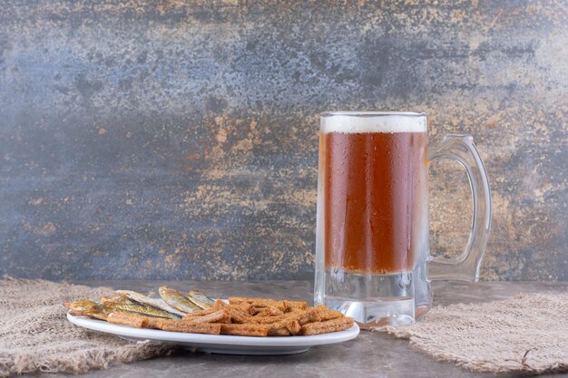 Plaat van vis en crackers met bier op marmeren tafel. Hoge kwaliteit foto
