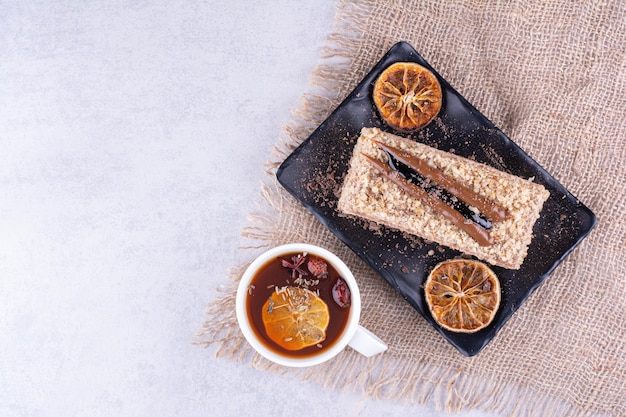 Plaat van zelfgemaakte cake met fruitthee op jute. Hoge kwaliteit foto