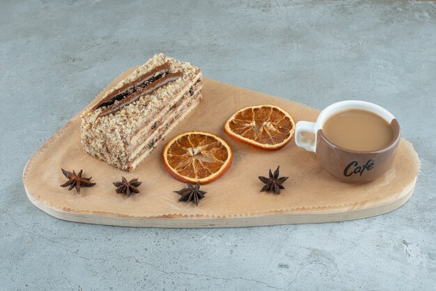 Plakje cake met stukjes sinaasappel en koffie op een houten bord. Hoge kwaliteit foto