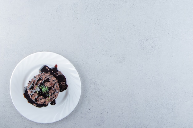 Plakje chocoladetaart versierd met siroop op witte plaat. Hoge kwaliteit foto