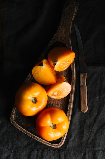 Plakjes oranje tomaten op een snijplank en mes