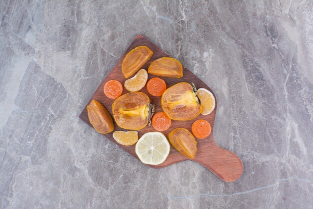 Plakjes persimmon, citroen, mandarijn en snoep aan boord.
