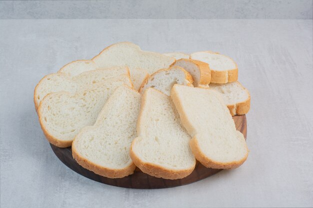 Plakjes vers wit brood op marmeren achtergrond.