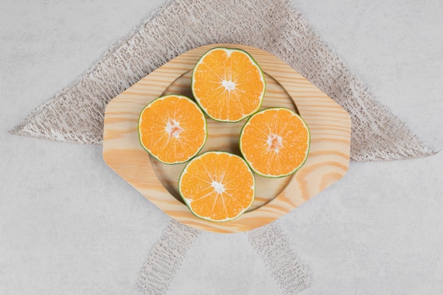 Plakjes verse mandarijnen op houten plaat. Hoge kwaliteit foto