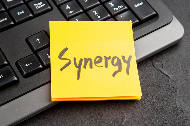 Plaknotitie met woord Synergy over toetsenbord