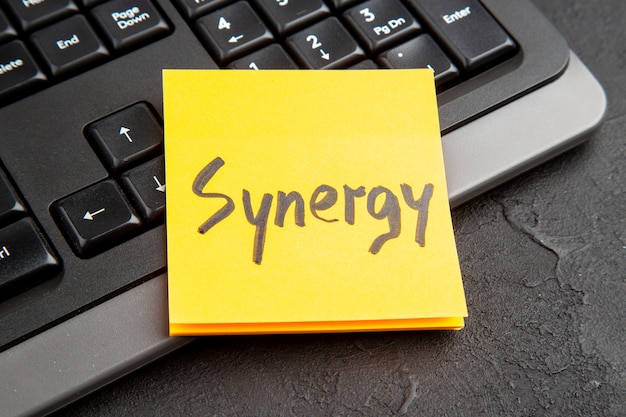 Plaknotitie met woord Synergy over toetsenbord