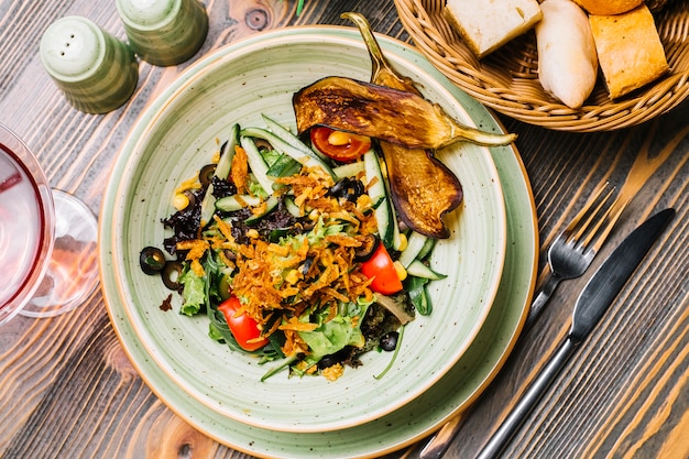 Plantaardige salade sla tomaat komkommer olijven likdoorns gebakken aubergines bovenaanzicht