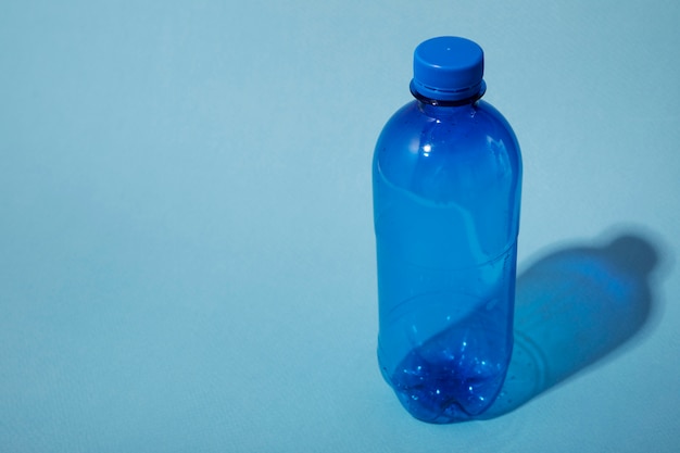 Plastic fles op blauwe hoge hoek als achtergrond