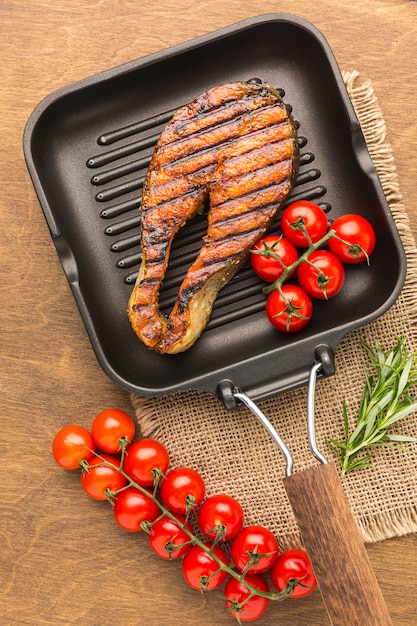 Plat lag gegrilde vis met tomaten