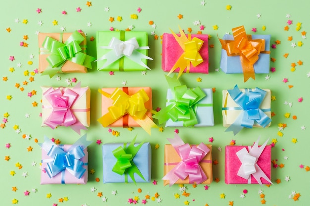 Plat lag kleurrijke geschenken op tafel met groene achtergrond