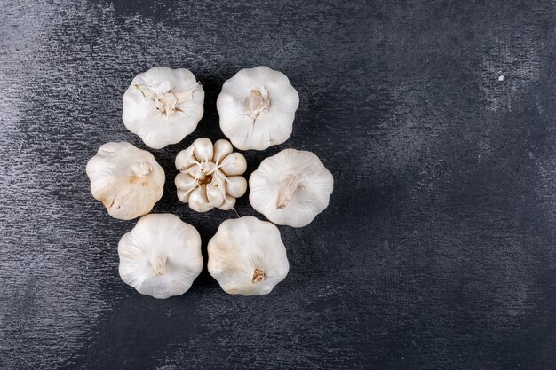 Plat lag knoflook vorm bloemvorm op donkere tafel