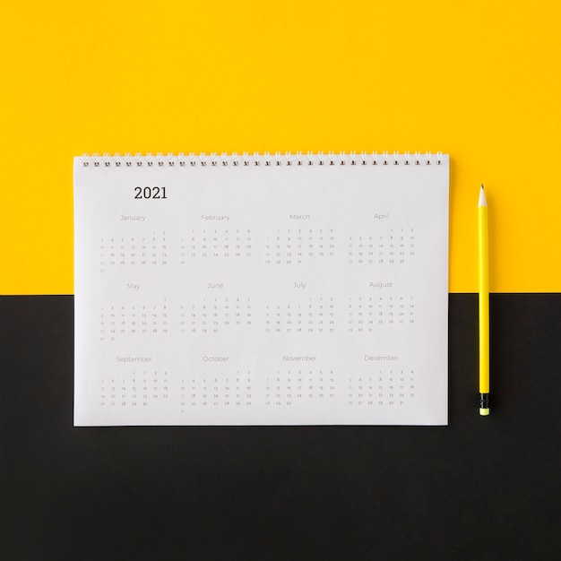 Gratis foto plat lag planner kalender op gele en zwarte achtergrond