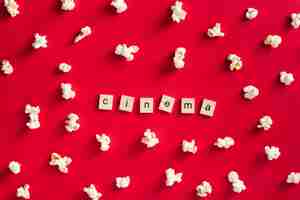 Gratis foto plat lag popcorn op rode achtergrond met bioscoop belettering