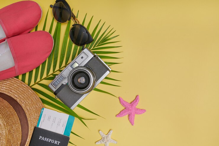 Gratis Foto plat lag reisaccessoires op gele achtergrond met palmblad, camera, schoen, hoed, paspoorten en zonnebril. bovenaanzicht reizen of vakantie concept. zomer gele achtergrond.