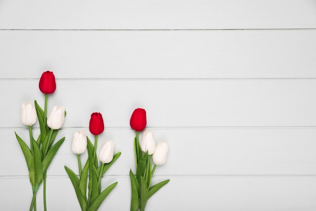 Plat lag rode en witte tulpen op tafel met kopie-ruimte