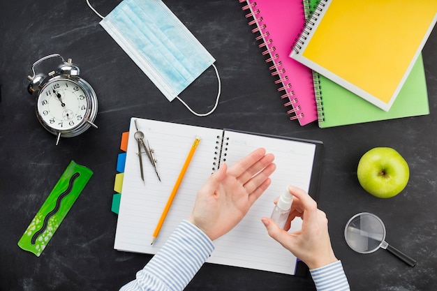 Plat lag student met behulp van ontsmettingsmiddel boven bureau