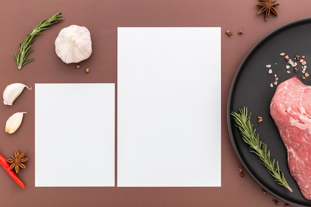 Plat lag van blanco menu papier met vlees op plaat en knoflook