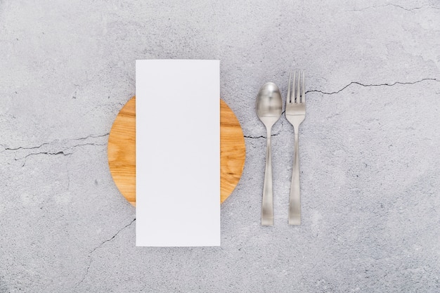 Plat lag van blanco menu papier op beton met bestek