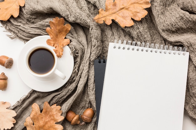 Plat lag van koffiekopje met textiel en herfstbladeren