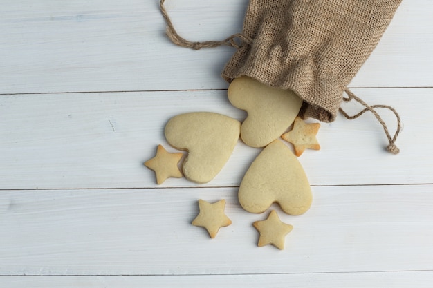 Plat lag verspreide koekjes uit zak op houten achtergrond. horizontaal